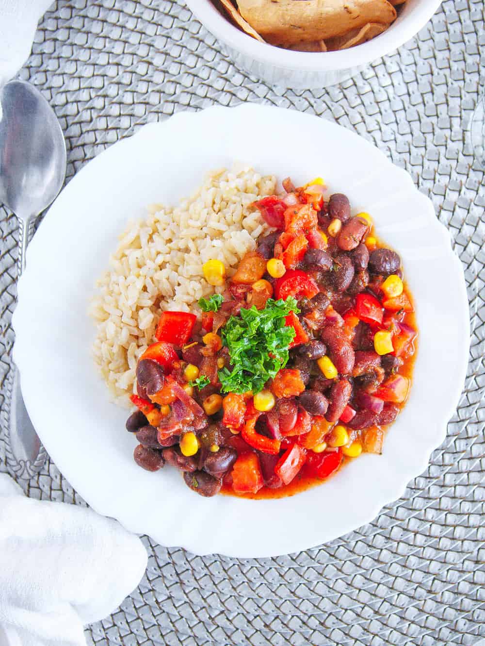 vegetarian stew recipe with beans and rice, served on a white plate with a spoon