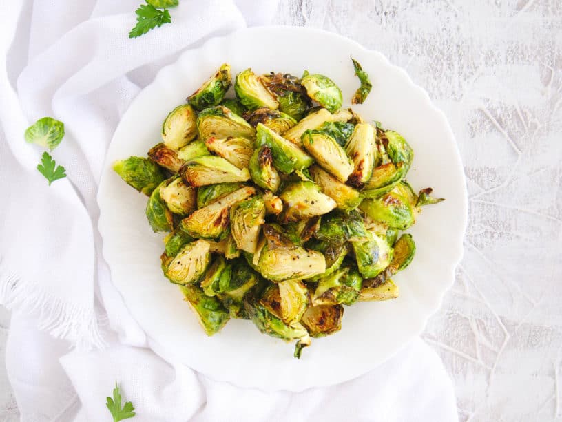 air fryer brussel sprouts served on a white plate, top view