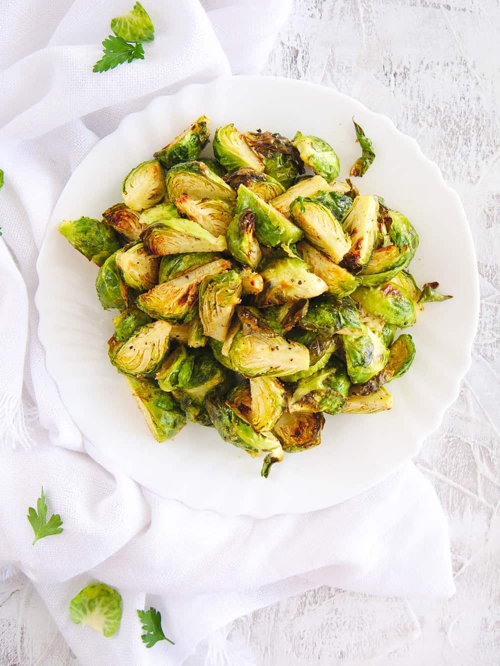 air fryer brussel sprouts served on a white plate, top view