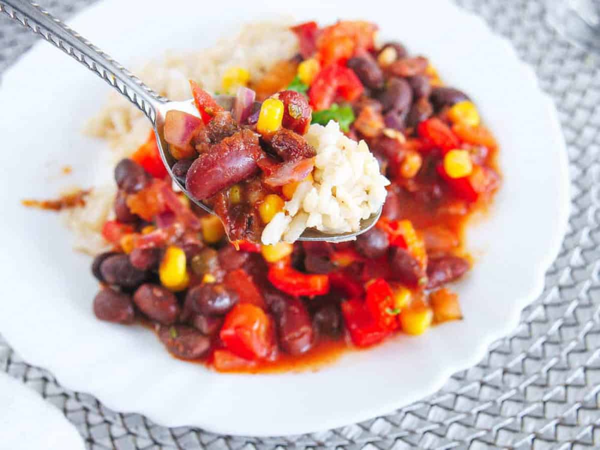 Spoonful of rice and bean stew over a bowl.