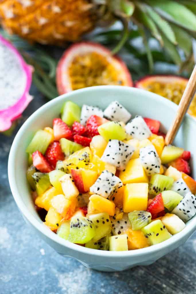 Mexican Fruit Salad with cubed melon, mango, jicama, dragon fruit, lime juice, and a hint of spicy chili - served in a blue bowl