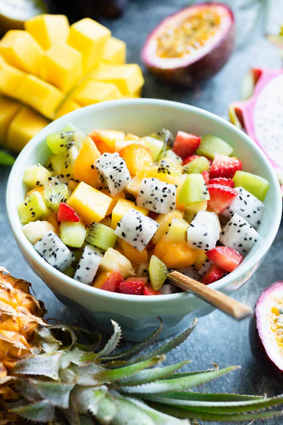 Mexican Fruit Salad with cubed melon, mango, jicama, dragon fruit, lime juice, and a hint of spicy chili - served in a blue bowl