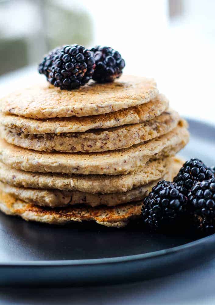 stake of vegan protein pancakes topped with blackberries