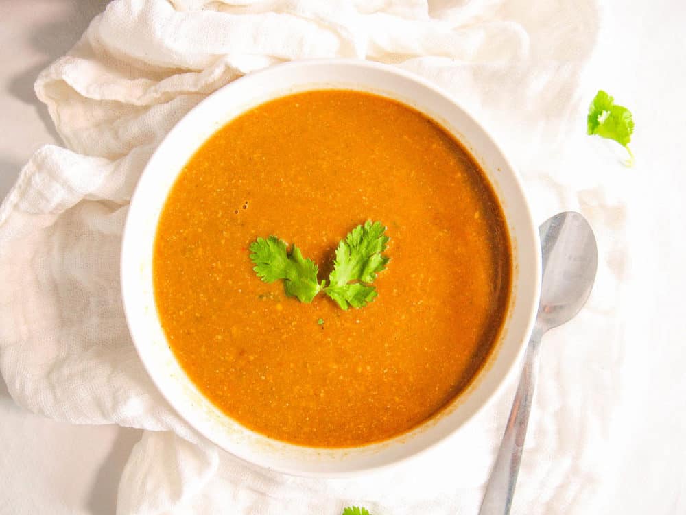 moroccan chickpea soup served in a white bowl with cilantro garnish