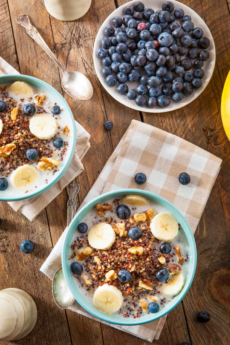 Quinoa Oatmeal with Nuts Milk and Berries, served in a blue bowl