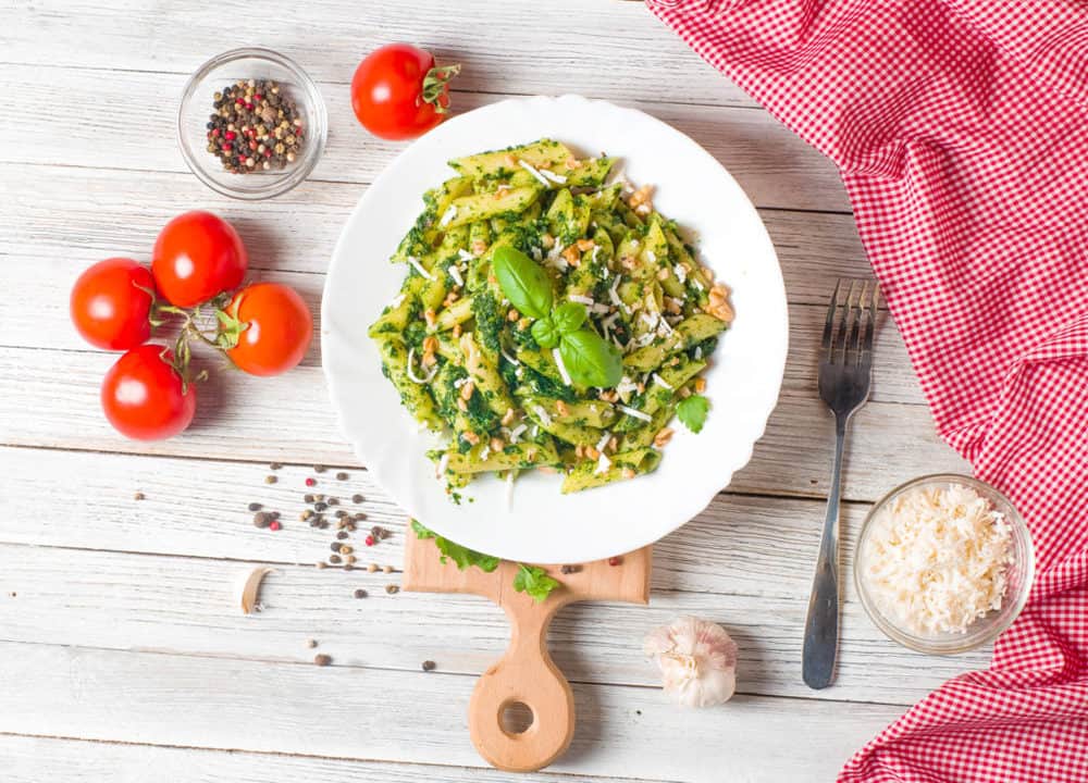 Vegetarian Pesto with Whole Wheat Pasta, topped with fresh basil, served on a white plate