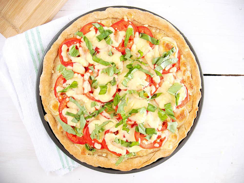 top view of margherita flatbread with basil and tomatoes