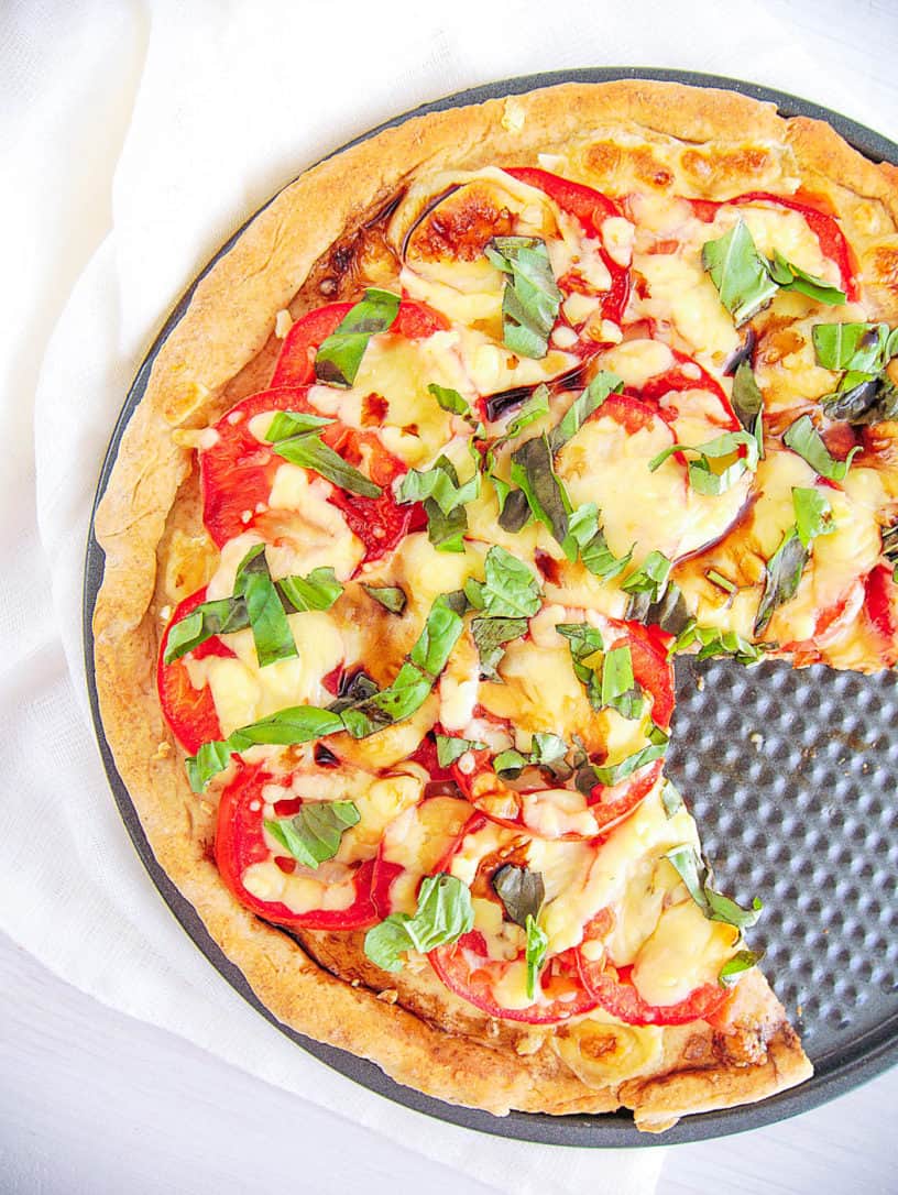 margherita flatbread with a slice cut out of the pie