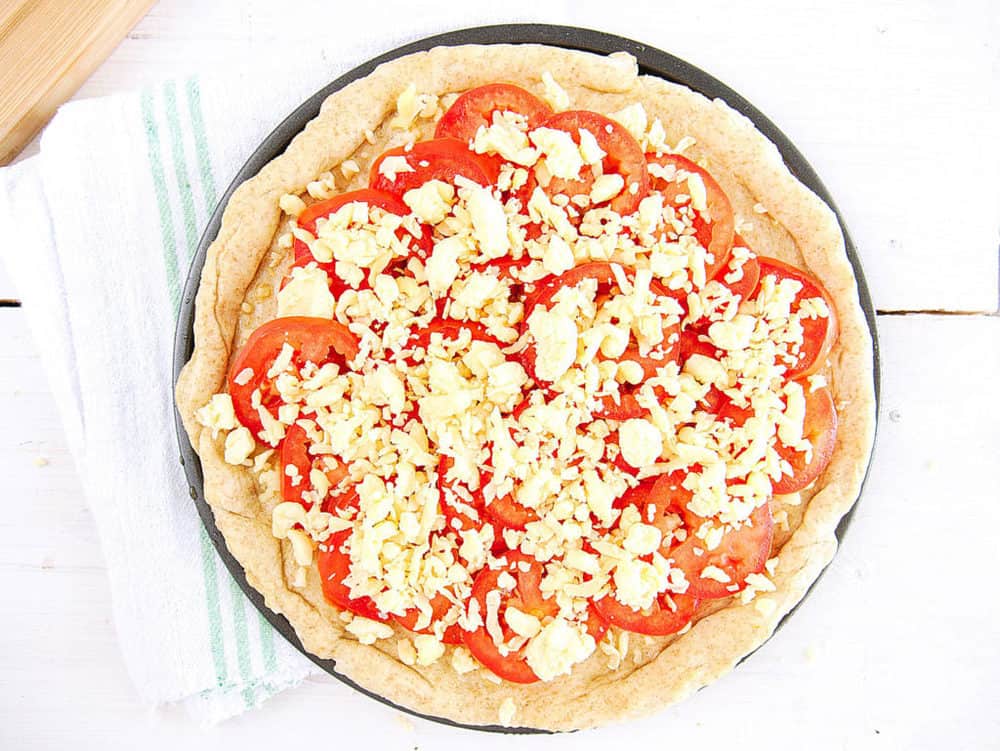 pizza dough topped with olive oil, garlic, tomatoes, cheese