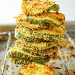 baked and crispy courgette chips with parmesan, stacked on an oven rack