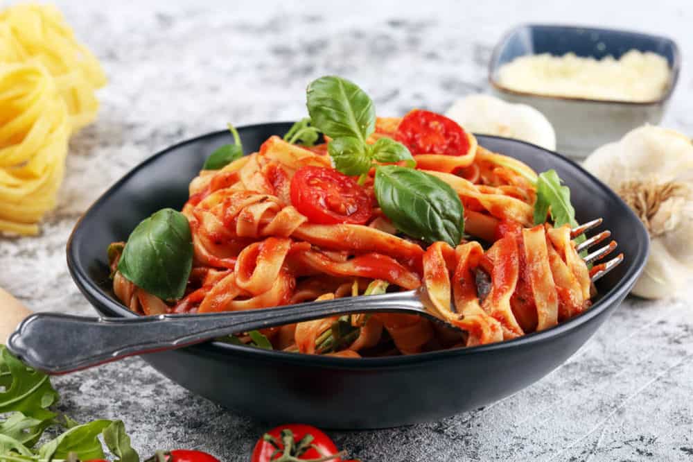 Vegetarian Spaghetti Sauce with whole wheat pasta, served in a black bowl with basil on top