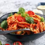 Vegetarian Spaghetti Sauce with whole wheat pasta, served in a black bowl with basil on top