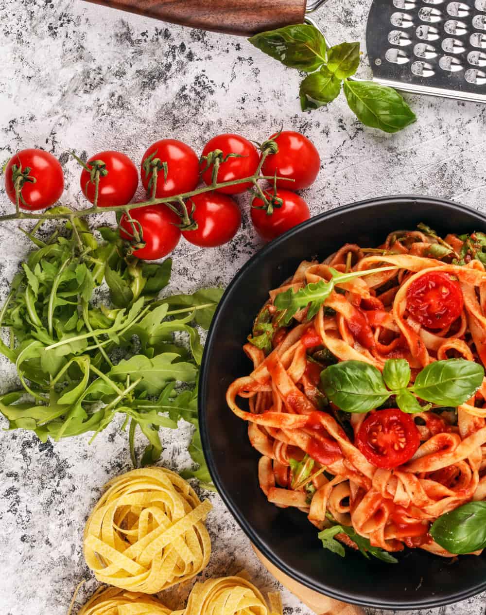 Vegetarian Spaghetti Sauce with whole wheat pasta, served in a black bowl with basil on top