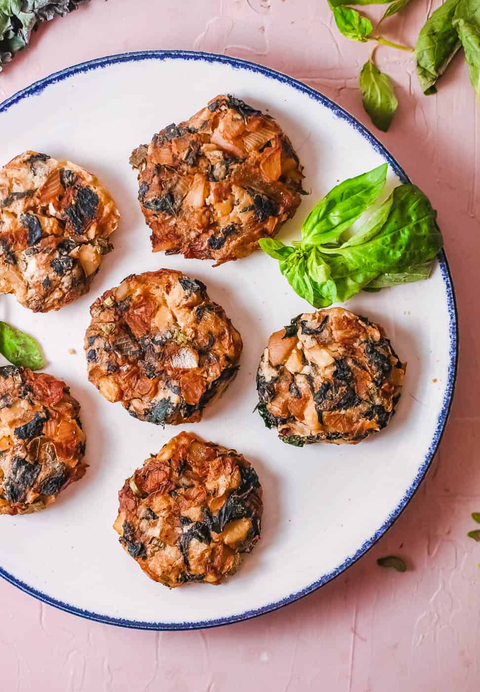 mashed potato fritters with onions and kale, served on a white plate, top view