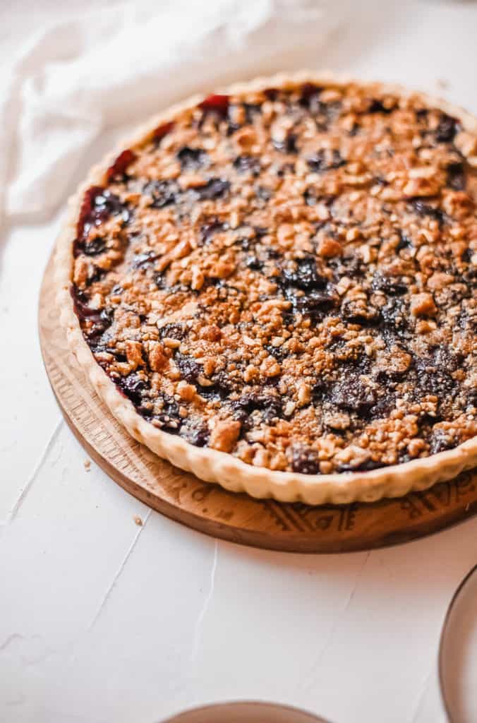 cherry crumb pie against a white background, side view
