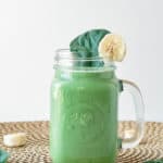 spinach banana smoothie with peanut butter served in a glass mason jar