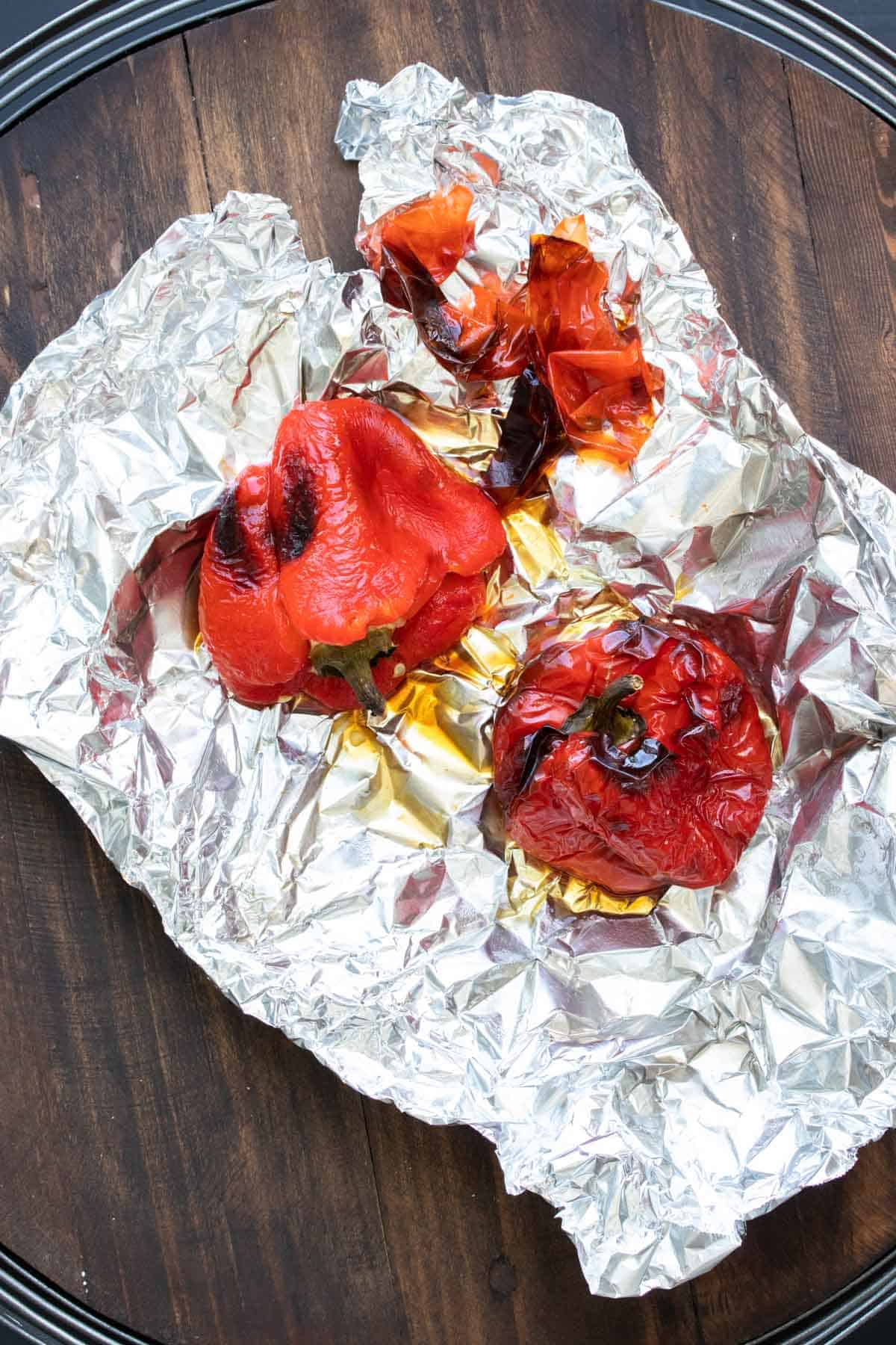 Tin foil with two roasted red peppers on it