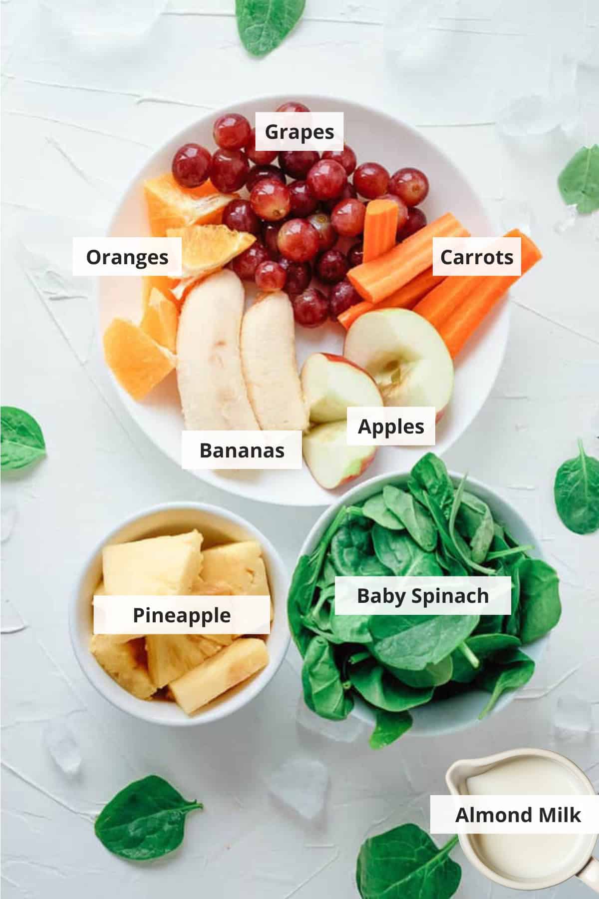 Ingredients for fruit and vegetable smoothie on a white countertop.