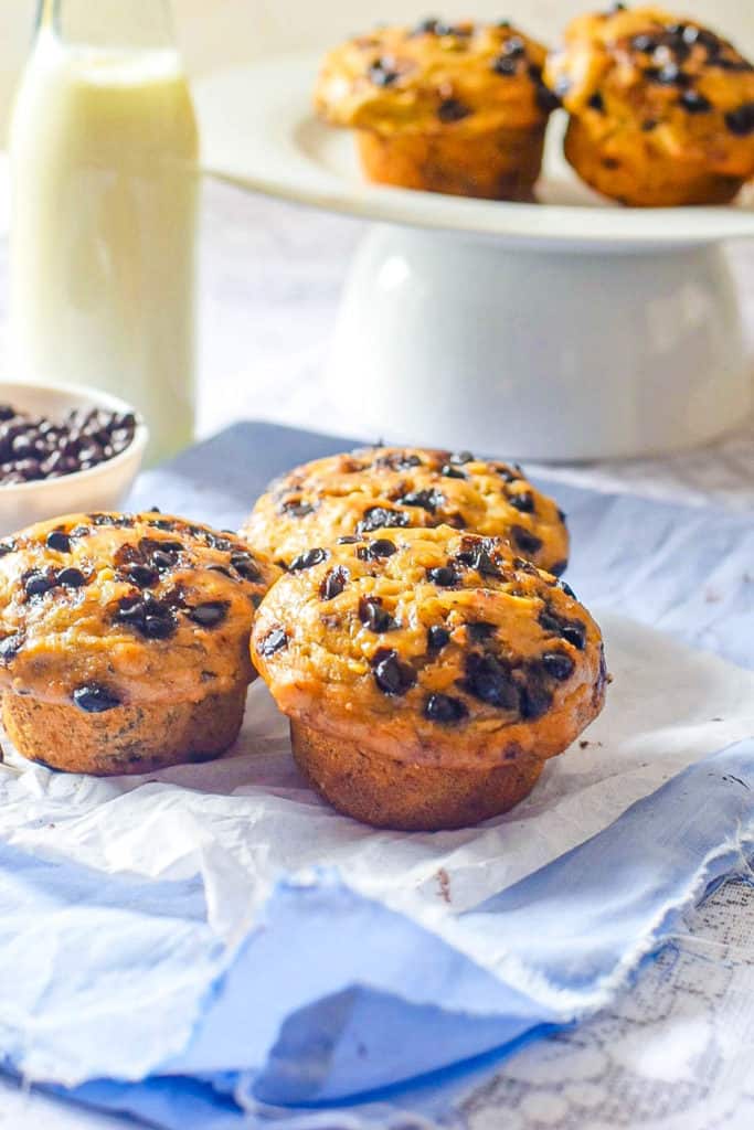 Chocolate Banana Muffin on a blue napkin with milk and muffins in the background