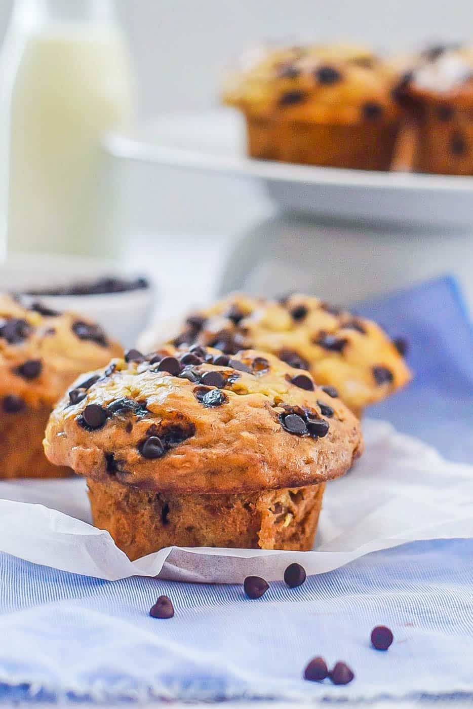 Chocolate Banana Muffin on a blue napkin with milk and muffins in the background