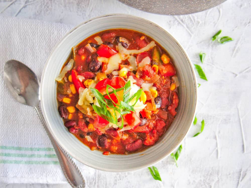 The Best Instant Pot Vegetarian Chili served in a white bowl topped with green onions and cheese