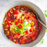 The Best Instant Pot Vegetarian Chili served in a white bowl topped with green onions and cheese