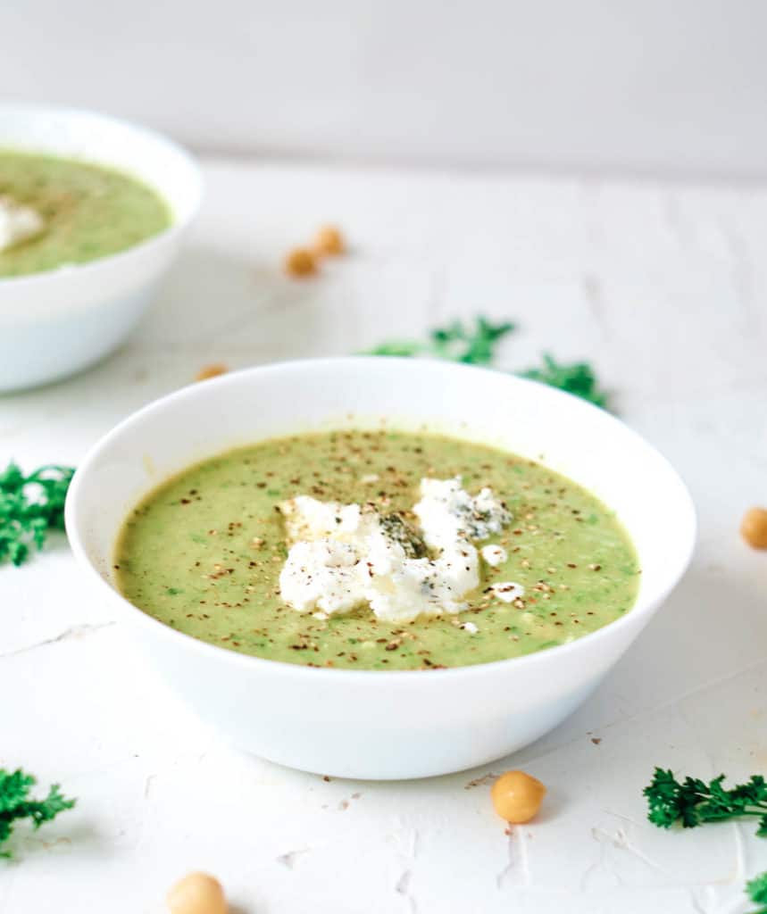 asparagus and leek soup with herbed goat cheese served in a white bowl