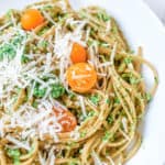 vegetarian pesto pasta with spinach and herbs, served on a white plate