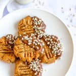 Keto Peanut Butter Cookies dipped in chocolate and nuts, on white plate