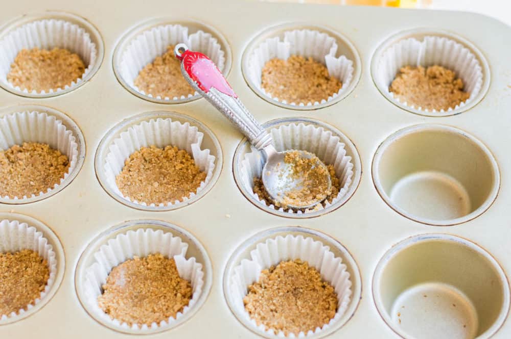 muffin tins filled with graham cracker crust