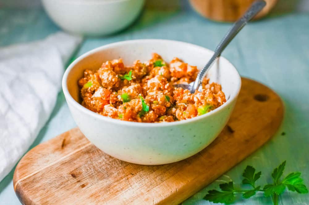 tofu in a white bowl on top of a wooden cutting board