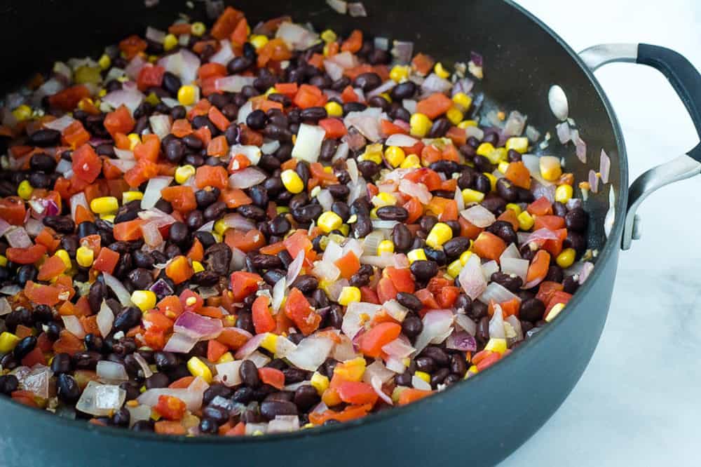 veggies and black beans in a large pan