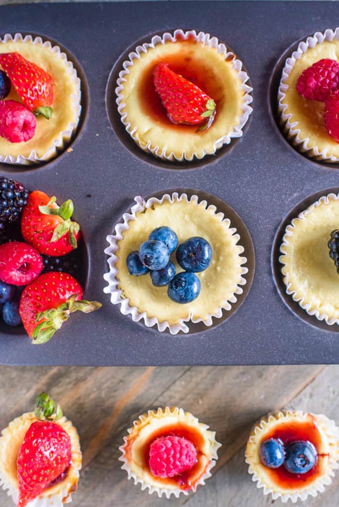 cheesecake bites topped with fresh fruit in a muffin tin