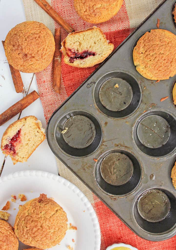 cinnamon muffins pictured both in a muffin tin and cut in half on a tray