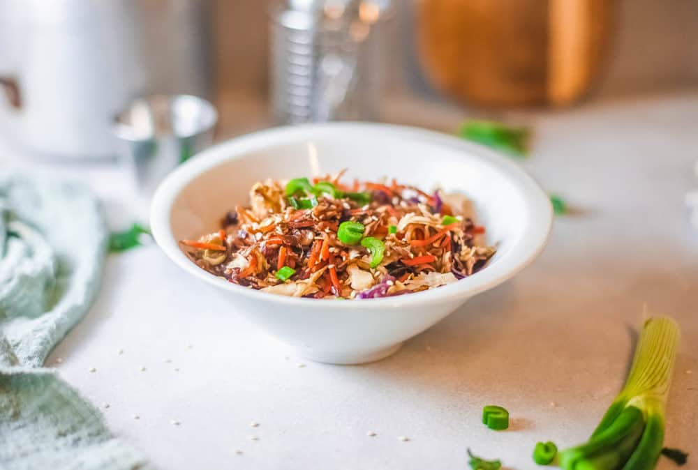 vegetarian egg roll in a bowl topped with green onions, served in a white bowl