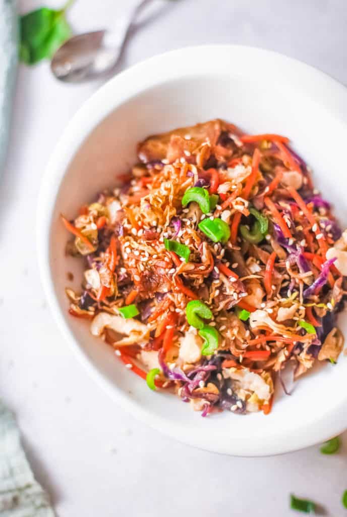 vegetarian egg roll in a bowl topped with green onions, served in a white bowl