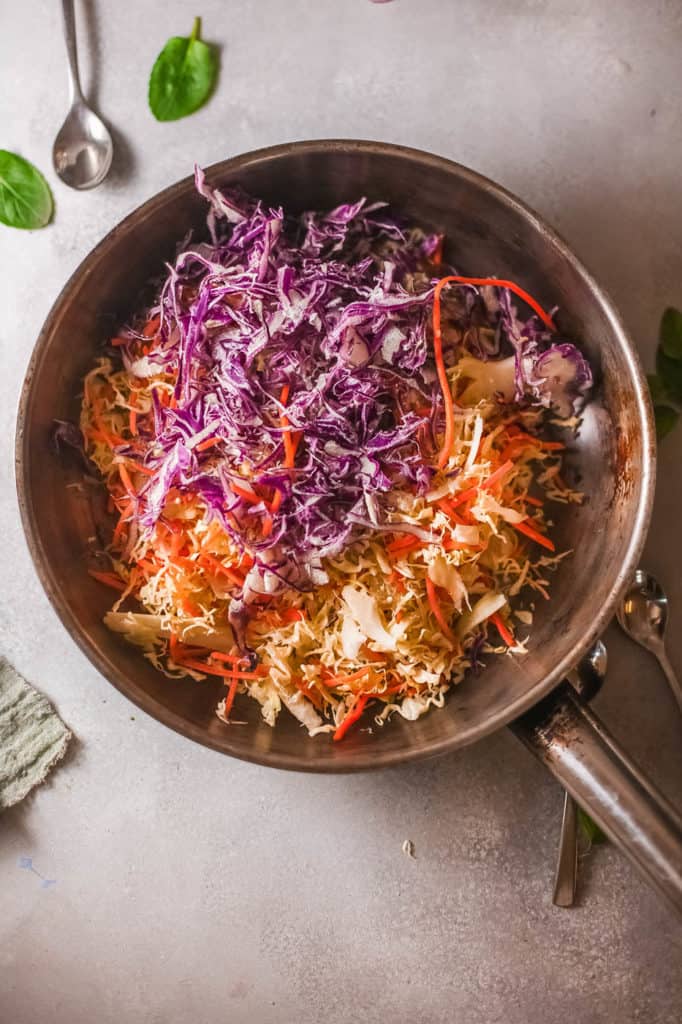cabbage and carrots sauteeing in a pan