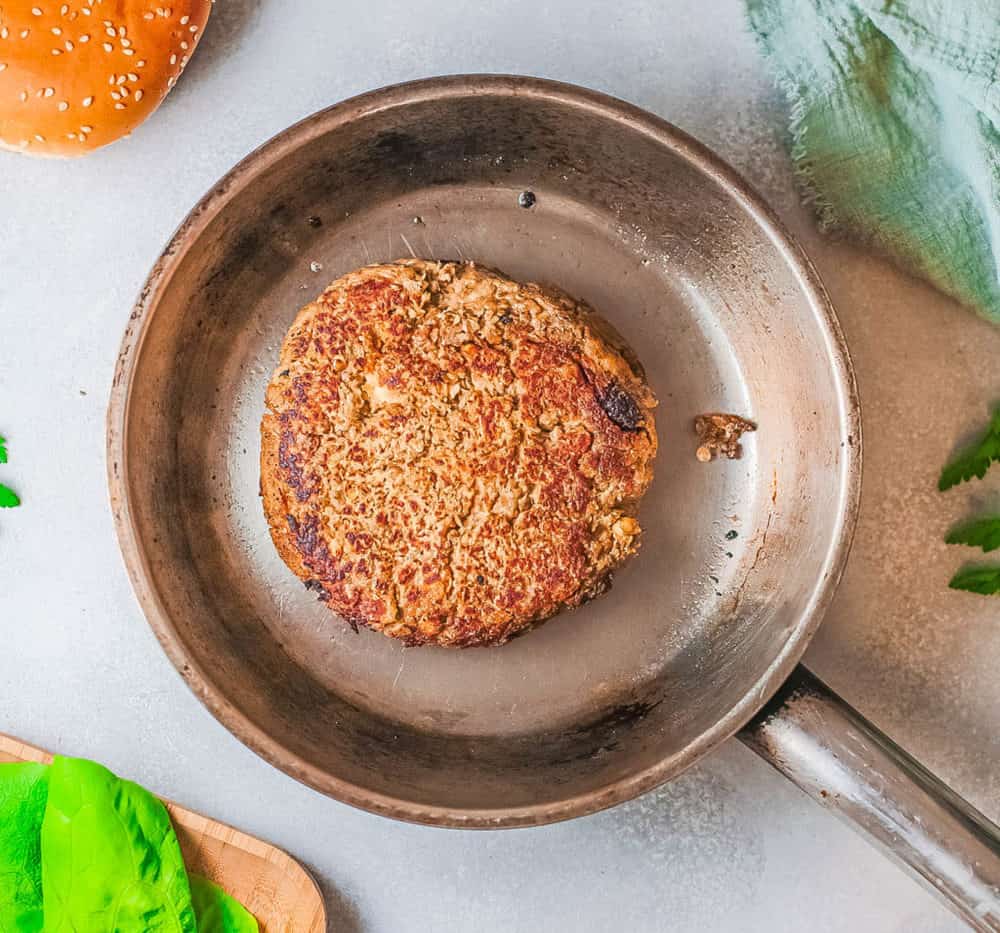 burger patty cooking in a pan