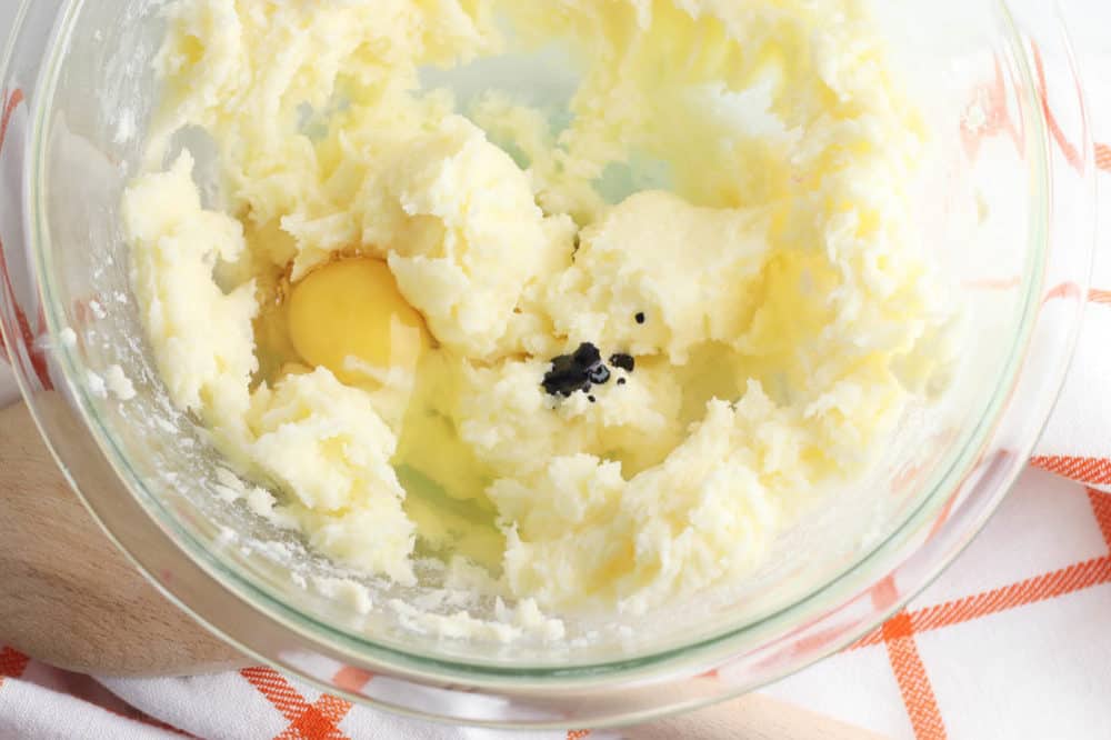eggs and vanilla added to butter mixture in a bowl