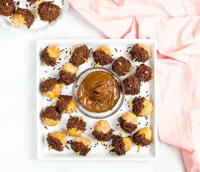 nutella donut acorns served on a white plate with milk in the background, top view