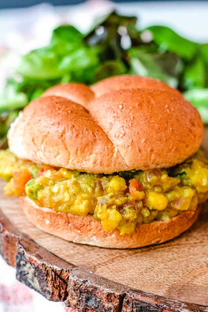 Pav Bhaji (or Indian Spiced Vegetarian Sloppy Joes) served on a wooden cutting board with a wheat bun