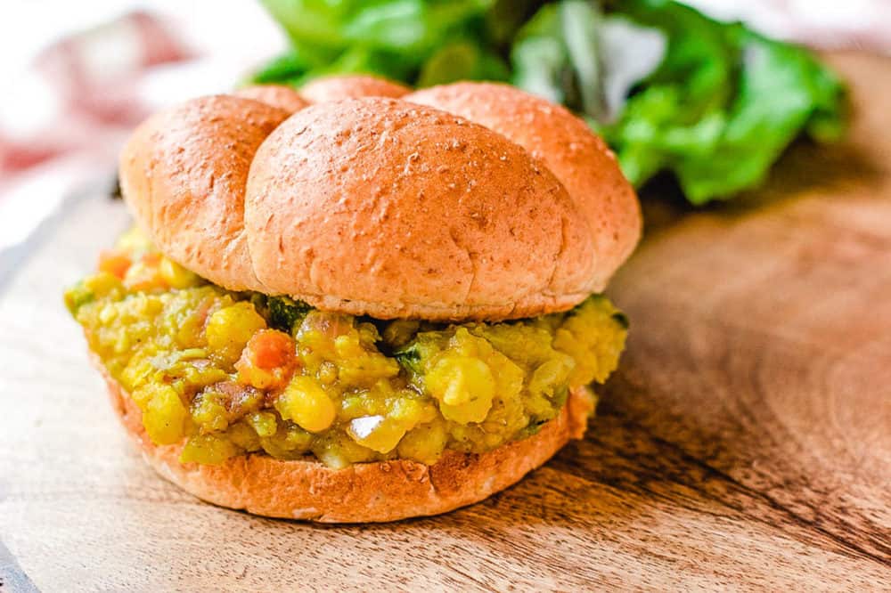 Pav Bhaji (or Indian Spiced Vegetarian Sloppy Joes) served on a wooden cutting board with a wheat bun