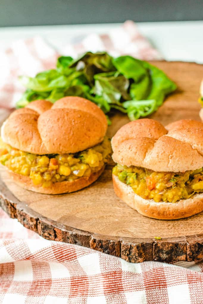Pav Bhaji (or Indian Spiced Vegetarian Sloppy Joes) served on a wooden cutting board with a wheat bun