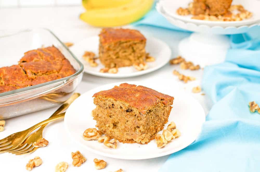 vegan banana bread, served on a white plate with a blue napkin in the background