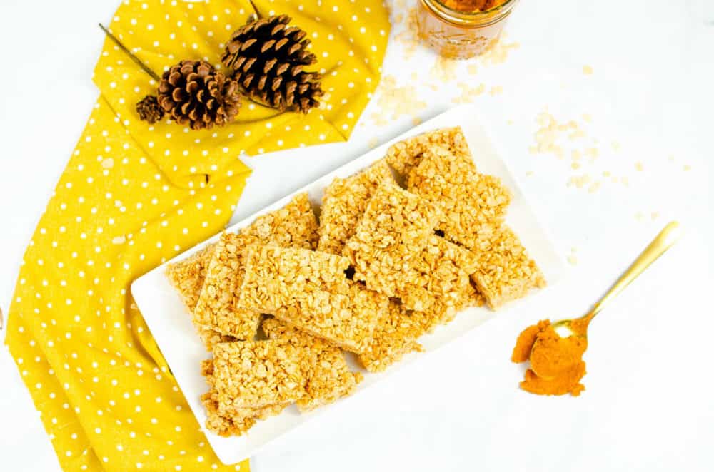 top view of vegan rice krispie pumpkin treats with pumpkin spice on a white platter