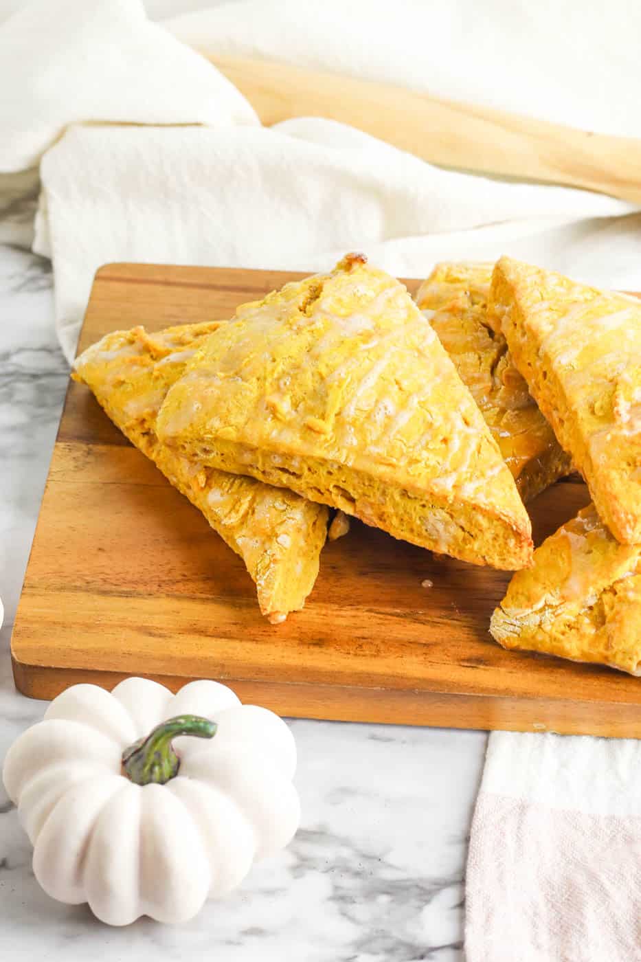 healthy vegan scones with pumpkin on a cutting board, drizzled with a maple glaze