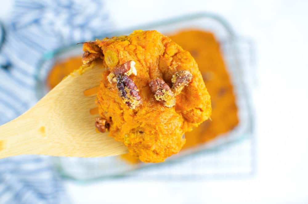 one scoop of vegan sweet potato casserole with pecans sprinkled on top