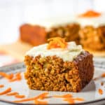 vegan carrot cake with cream cheese frosting on a white plate