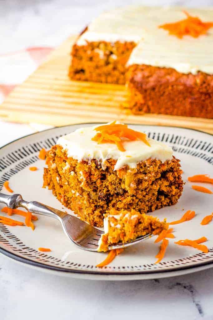 vegan carrot cake with cream cheese frosting on a white plate