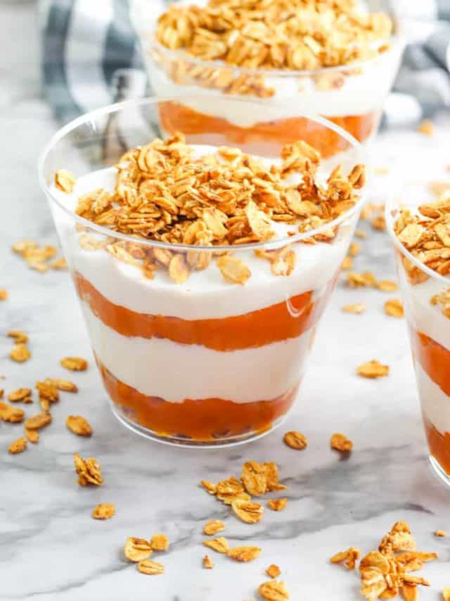 Small cups of pumpkin parfait on a counter with oats.